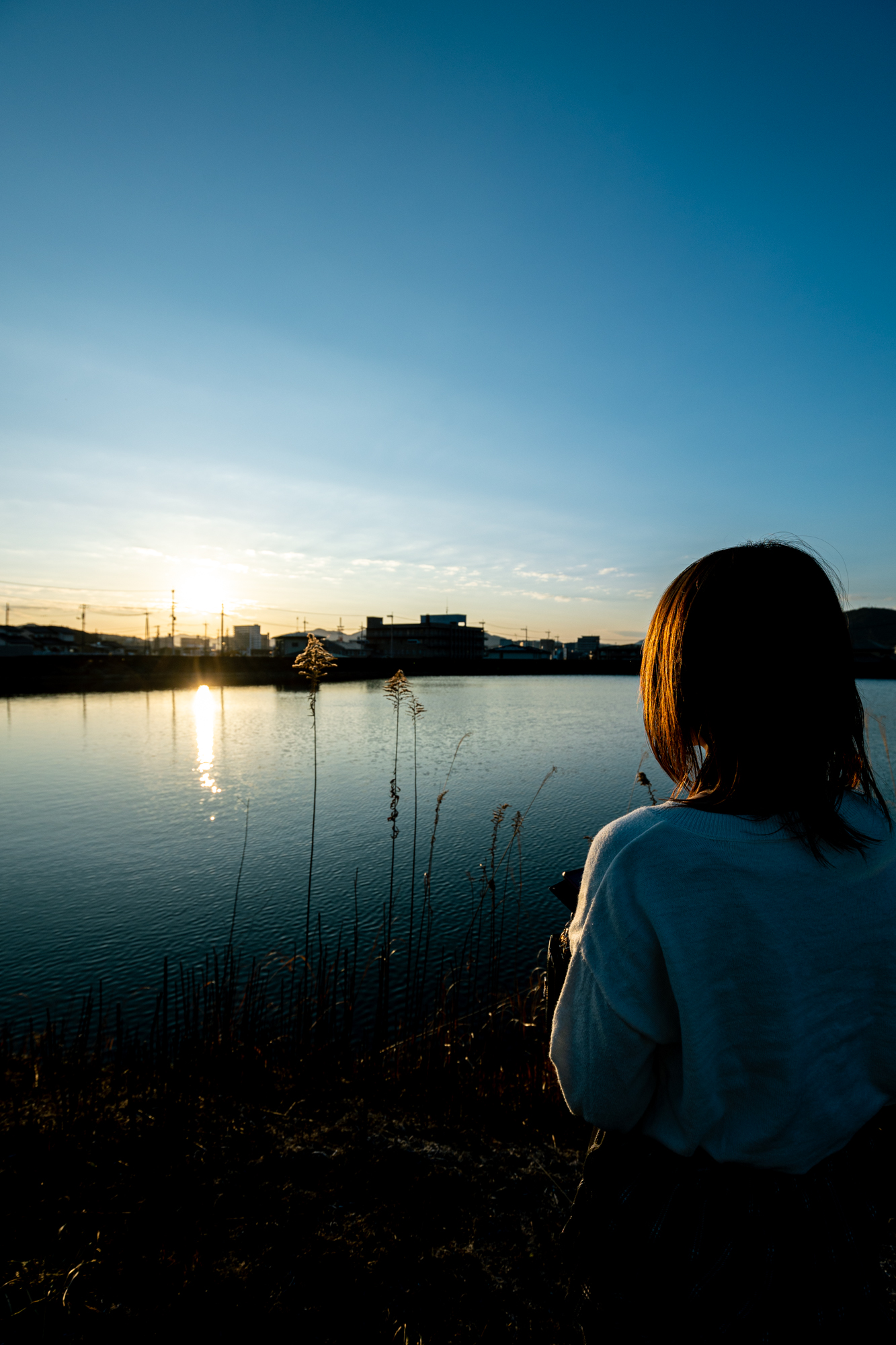 夕日と女性の背後